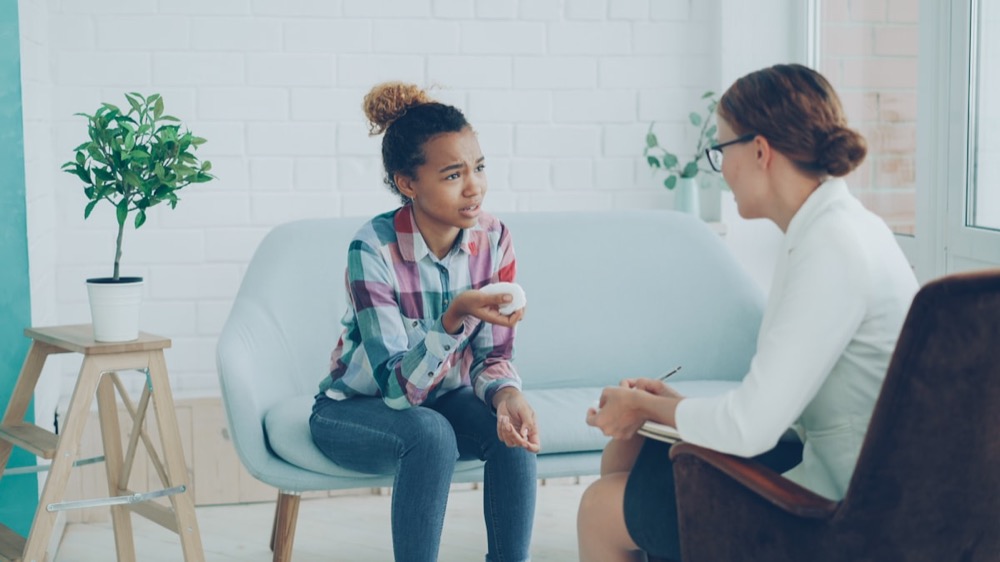 A therapist listening attentively to a young girl during a session