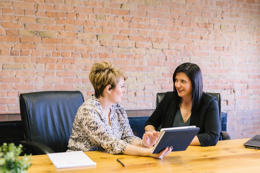 Two colleagues seated together in a supportive, professional conversation
