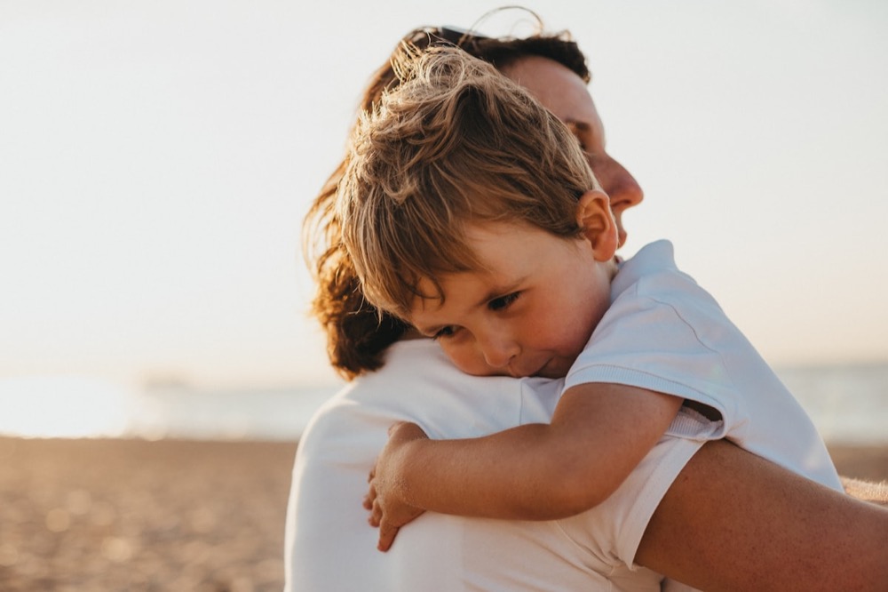 A parent embracing a child in a warm, reassuring hug