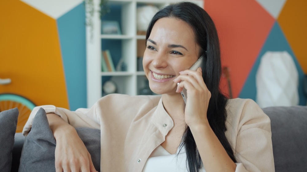 A woman smiling while talking on the phone