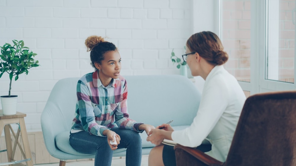 A therapist talking with a teenager during a counseling session